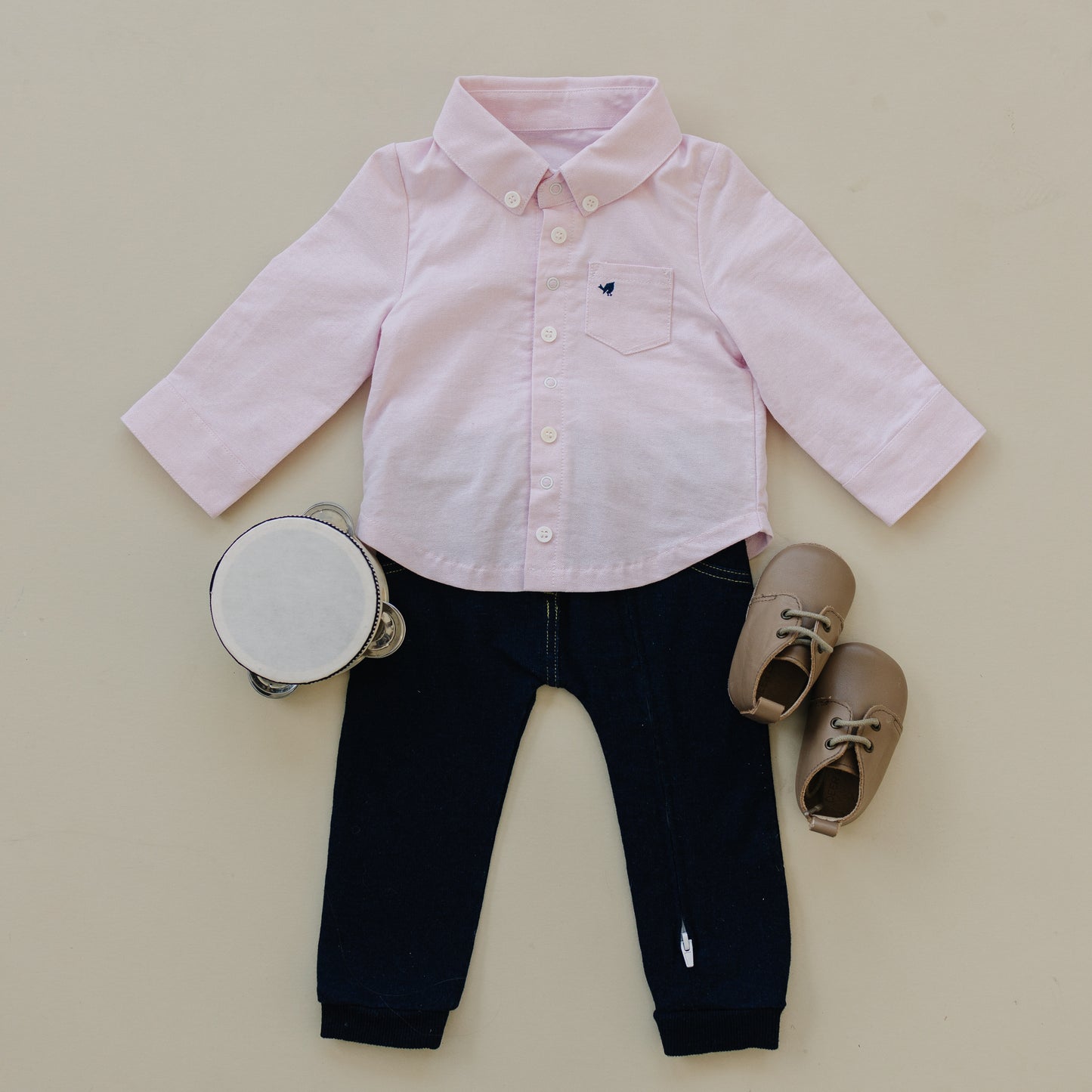 Preppy baby boy coming home outfit with pink oxford top and soft denim pants seen with toys. Clothes come in 0-3 month size.