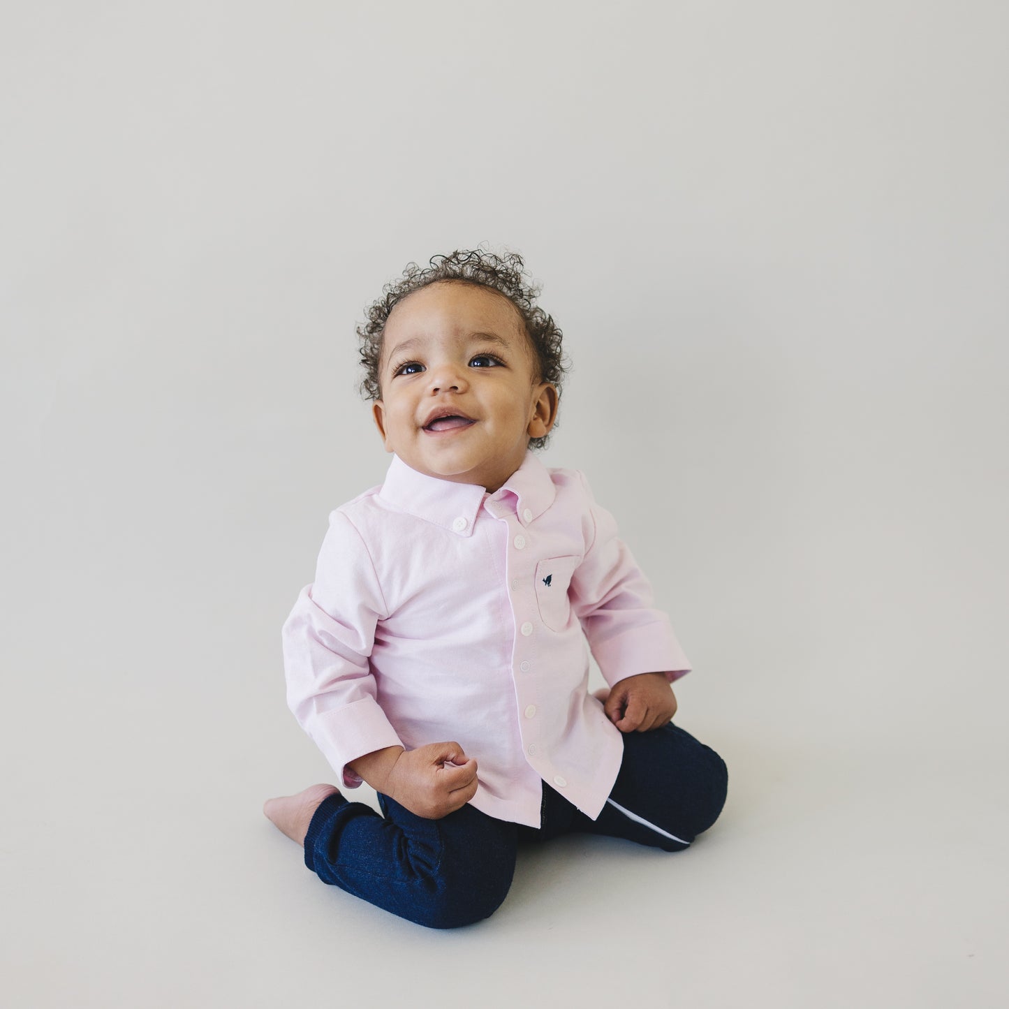 Happy baby boy wearing preppy baby clothes. Outfits range in size from 0-3 month clothes to 9 12 month clothes.